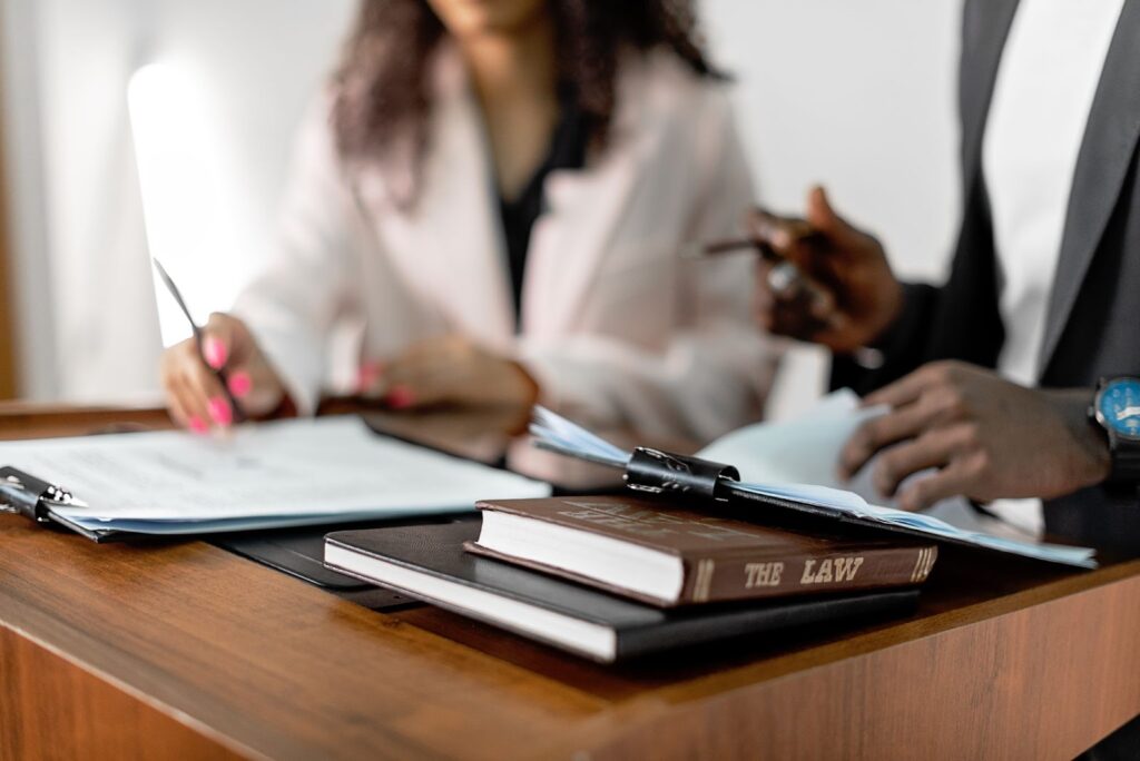 A photo of a man and woman at a divorce attorney’s desk with paperwork.