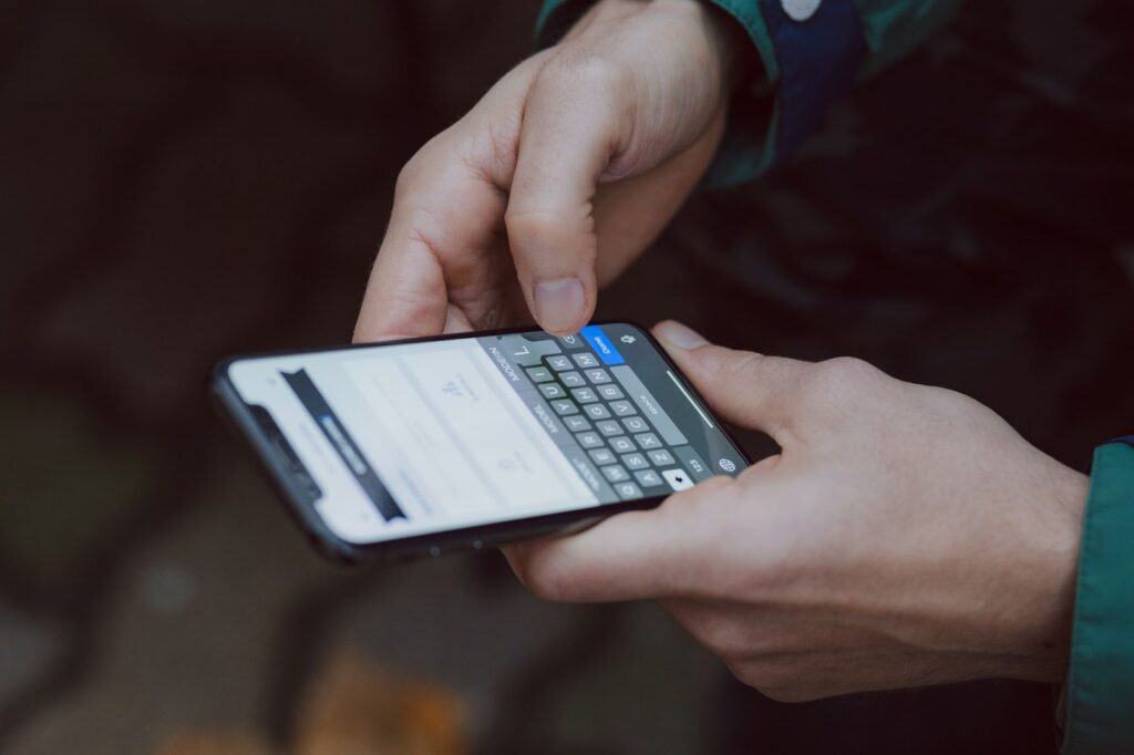 A person holding a cell phone and texting. 