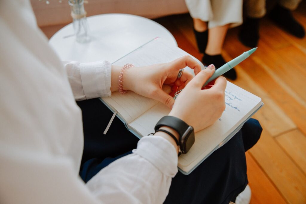 A photo of a woman at a divorce consultation with a notepad in her lap.